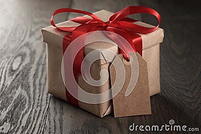 Rustic gift box with red ribbon bow and empty tag Stock Photo