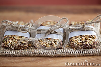 Rustic Granola Bars wrapped with Twine on Burlap Red BG Stock Photo