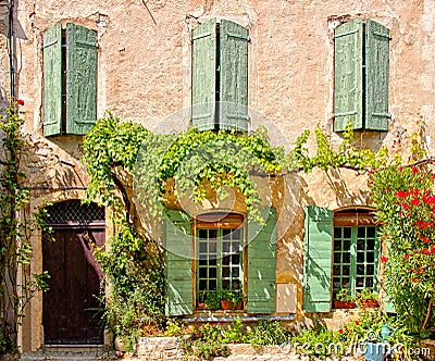 House front with shuttered windows and leafy facade, Provence, France Stock Photo