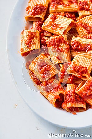 Rustic italian paccheri pasta in tomato sauce Stock Photo