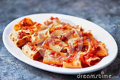 Rustic italian paccheri pasta in tomato sauce Stock Photo