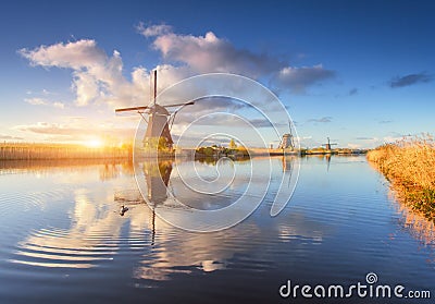 Rustic landscape with amazing dutch windmills at sunrise Stock Photo