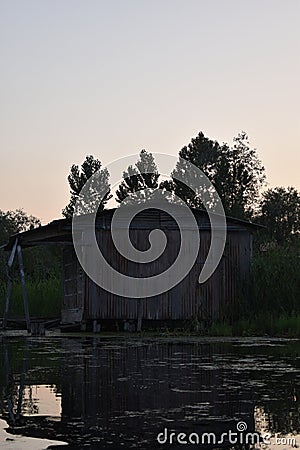 Rustic look of a old house made of tin with sunset sky background in the middle of Dal lake, Srinagar, Jammu and Kashmir, India Stock Photo