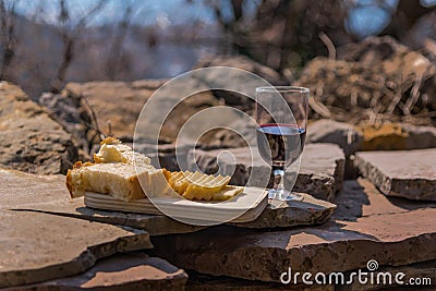 Rustic Lunch on the stone wall: homemade cheese, bread and wine. Mountain village Stock Photo