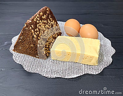 A rustic lunch on the table, cheese, brown bread. Stock Photo