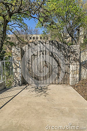 Rustic and old arched wooden gate at the entrance of a private property Stock Photo