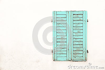 Rustic old grungy and weathered green cyan wooden closed window shutters with peeling paint Stock Photo