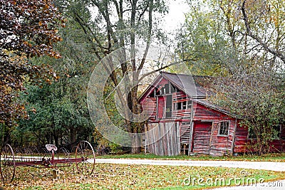 Rustic Old Abandoned Barn with Antique Plow Stock Photo