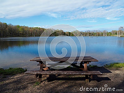 Rustic picnic table next to mountain lake Stock Photo