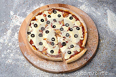 Rustic pizza on wooden board. whole pizza with tomato sauce, a lot of cheese with black Olives on top Stock Photo