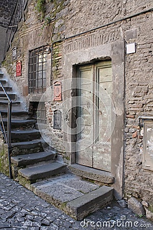 Vintage door, stone stairs, textured wall in old European alley Stock Photo