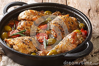 Rustic style chicken baked with green olives, tomatoes and onions, herbs close-up in a pan. horizontal Stock Photo