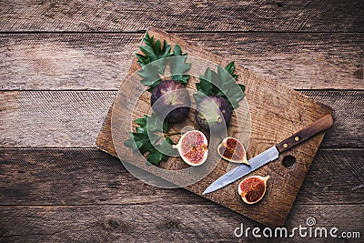 Rustic style Cut figs with knife on chopping board and wooden ta Stock Photo