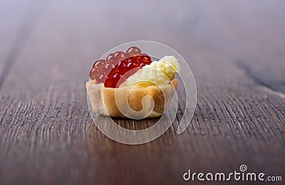 Tartlet with red caviar and butter on a wooden background Stock Photo