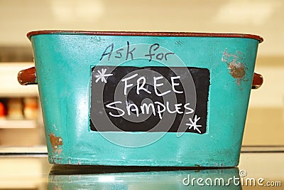 Rustic tin basket sitting on counter that says Ask for free samples Stock Photo