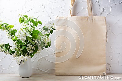 Rustic tote bag mockup with flowering apple tree branch Stock Photo