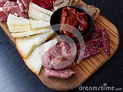 Rustic Tuscan tray with typical products: prosciutto ham, brawn, finocchiona, crostini, salami, tuscan chilli and sliced pecorino Stock Photo