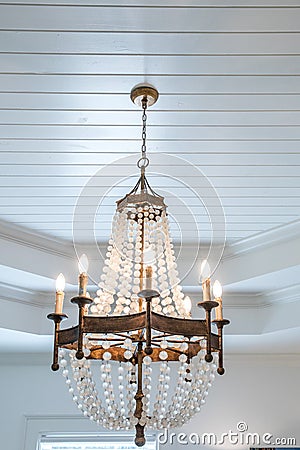 rustic wood and beaded hanging beach or coastal themed chandelier in a living room Stock Photo