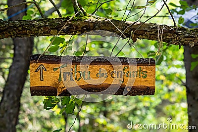 Rustic wood sign hangs from tree branch Stock Photo