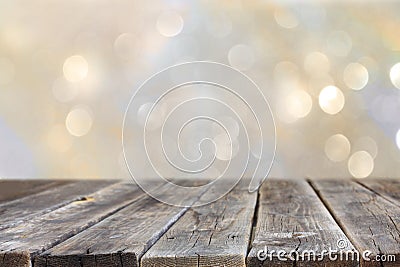 Rustic wood table in front of glitter silver and gold bright bokeh lights. Stock Photo