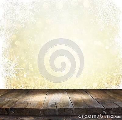 Rustic wood table in front of glitter silver and gold bright bokeh lights with snowflacke overlay Stock Photo