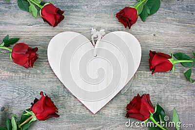 Rustic Wooden Heart and Red Roses Over Wooden Background for Valentine`s Day Holiday Stock Photo