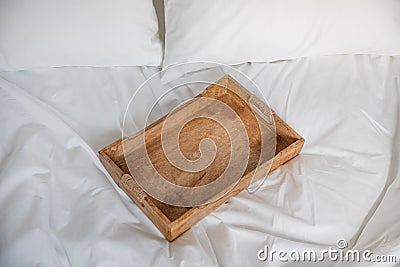 Rustic wooden tray on a white bed. Romantic breakfast in a bed Stock Photo