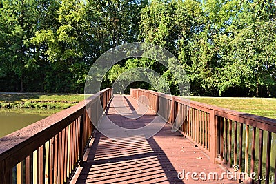 Rustic Wooden Walking Bridge Over Pond Stock Photo