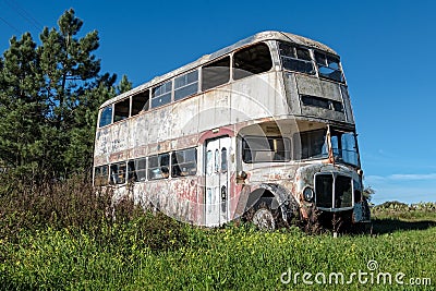 Rusty Abandoned Double-Decker Bus Standing in a Field Stock Photo