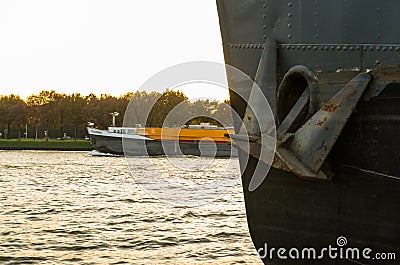 Rusty anchor is hanging on a black industrial ship Editorial Stock Photo