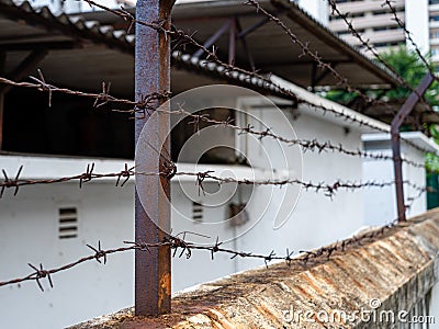 Rusty barbed wire fence perimeter around an abandoned building compound for security or containment purposes Stock Photo