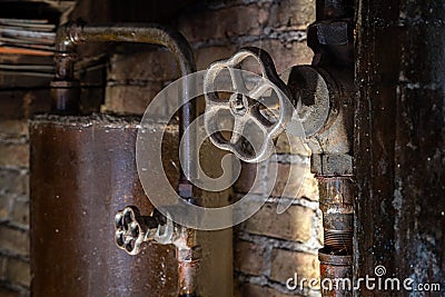 Rusty boiler room pipes. Old metal boiler generating heating and delivering it to home through pipeline. Hot water or gas is being Stock Photo