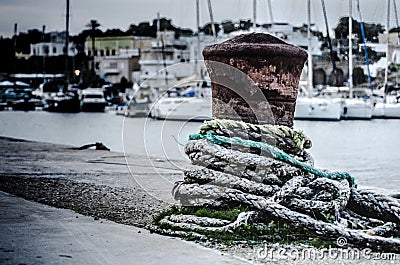 Rusty bollard with rope Stock Photo