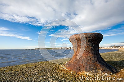 Rusty bollard on a sea wall Stock Photo