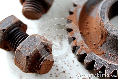 Rusty bolts, nuts and gear wheel made of chocolate on white background Stock Photo