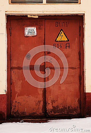 Rusty door, danger high voltage Stock Photo
