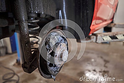 Rusty drum brakes, rear on red car. Change the old to new brake disc on car in a garage. Auto mechanic repairing Stock Photo