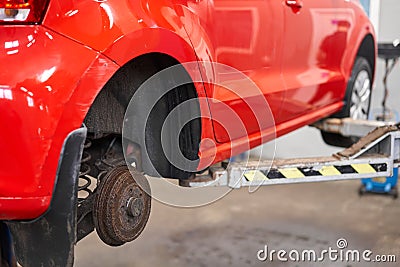 Rusty drum brakes, rear on red car. Change the old to new brake disc on car in a garage. Auto mechanic repairing Stock Photo