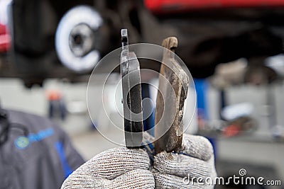 Rusty drum brakes, rear on red car. Change the old to new brake disc on car in a garage. Auto mechanic repairing Stock Photo