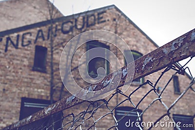 Rusty fence in front of old brick building Stock Photo