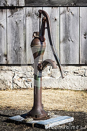 Rusty Hand Water Pump and Old Barn Boards Stock Photo