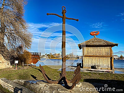 Rusty iron military anchor as decoration on the coast Editorial Stock Photo