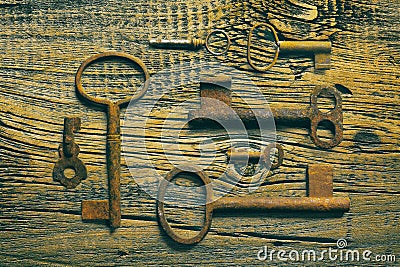 Rusty medieval keys on worn out wood table Stock Photo