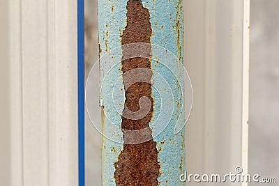 A rusty metal pole with blue paint falling off Stock Photo