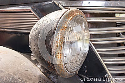 A rusty old car front headlight close up Stock Photo