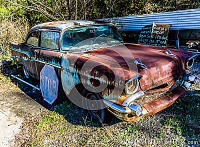 Rusty, old, junked car in the woods Stock Photo