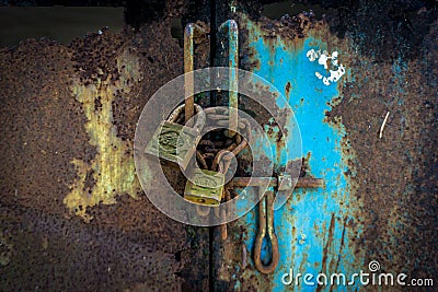 Rusty padlocks with chains still locking the gate with blue colour photo taken in Jakarta Indonesia Stock Photo