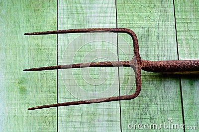 Rusty pitchfork on wooden planks Stock Photo