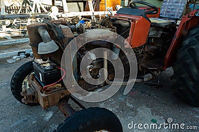 Rusty red tractor with the engine uncovered close up Editorial Stock Photo