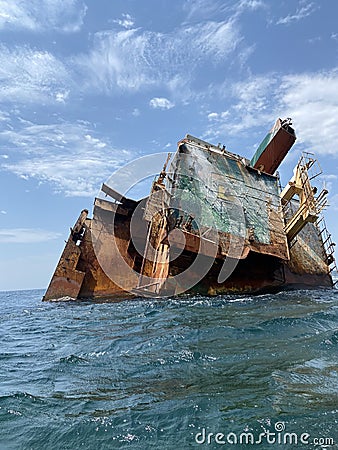 Rusty remains of a sunken ship submerged in water Stock Photo